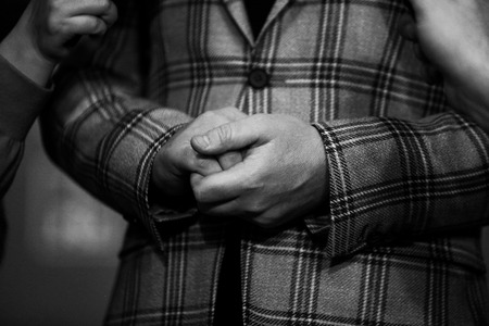 Black and white image with details of hands of a politician while being interviewed by the press