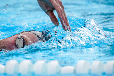 Details with a professional athlete swimming in swimming poolの写真素材