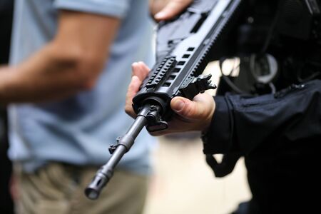 Details with the hands of a man holding an automatic rifleの写真素材