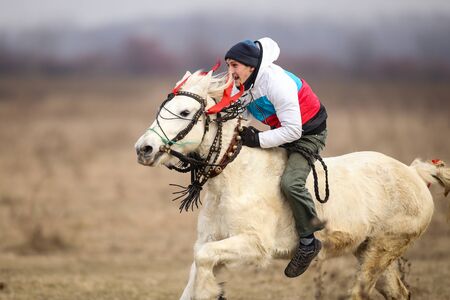 Pietrosani, Romania - January 6, 2019: Man is bareback riding an adorned horse before an Epiphany celebration horse race.のeditorial素材