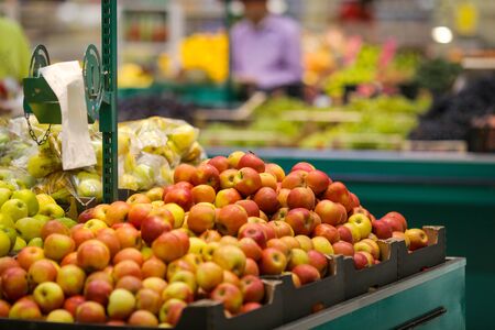Red apples on the fruits and vegetables aisle in a store.の写真素材