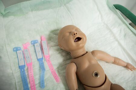 Details with a plastic dummy representing a newly born baby used by medics and midwives for childbirth practiceの写真素材