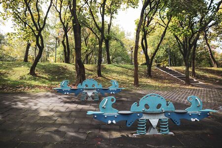 Colorful children's playground with slides, swings and other objects in a public park with many...