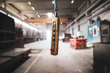 Shallow depth of field (selective focus) image with a worn out suspended industrial control panel with switches in a factory.の写真素材