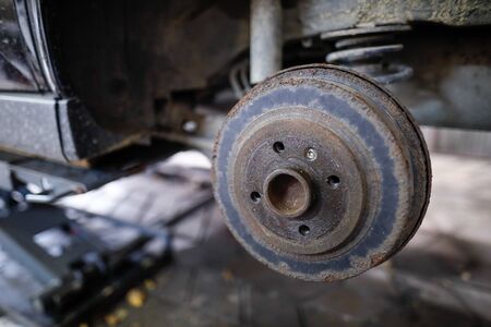 Shallow depth of field (selective focus) image with a rusty rear wheel hub of an old car.の写真素材