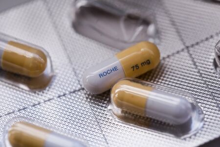 Bucharest, Romania - January 27, 2020: Close up image with a Tamiflu capsule (oseltamivir) on a...