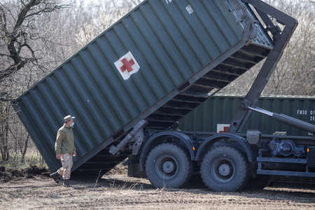 Otopeni, Romania - February 19, 2020: Personnel of the Romanian Army work on the installation of a campaign mobile hospital (ROL 2) to treat Covid-19 patients.のeditorial素材