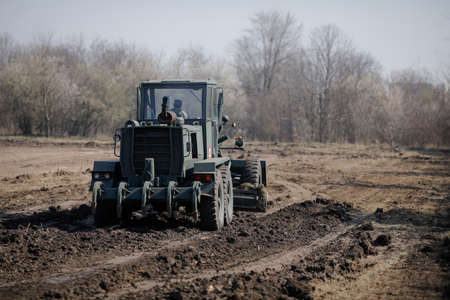 Otopeni, Romania - February 19, 2020: Heavy machinery of the Romanian Army level the ground for a campaign mobile hospital (ROL 2) to treat Covid-19 patients.のeditorial素材