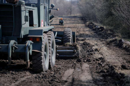 Otopeni, Romania - February 19, 2020: Heavy machinery of the Romanian Army level the ground for a campaign mobile hospital (ROL 2) to treat Covid-19 patients.のeditorial素材