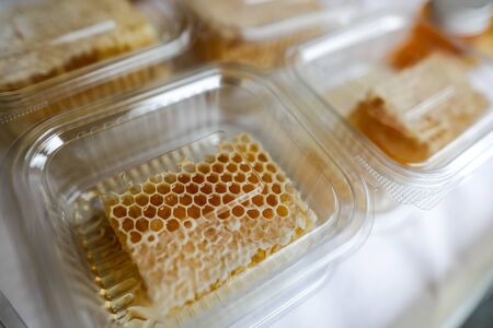 Honeycomb in plastic recipient for sale in a market.の写真素材