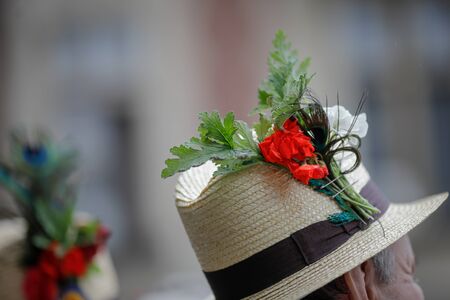 Details with the traditional Romanian straw hat of a senior man, adorned with flowers and leaves.の写真素材
