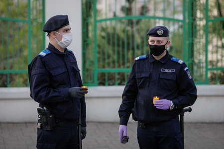 Bucharest, Romania - April 18, 2020: Romanian gendarmes with surgical masks due to the covid-19 pandemic take the Holy Light during the orthodox Easter.のeditorial素材