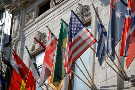 Bucharest, Romania - April 22, 2020: Various national flags wave on the exterior of a closed hotel in Old Town Bucharest during the covid-19 lockdown.のeditorial素材