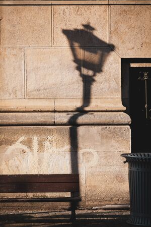 Shadow of a lamp post is casted on the surface of an old building in downtown Bucharest.