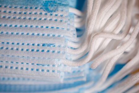 Shallow depth of field (selective focus) image with details of mouth and nose surgical unused masks...