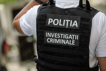 Bucuresti, Romania - June 14, 2020: Details with the vest of a Romanian police officer with the text âPolitia. Investigatii Criminaleâ (Police. Crimnial Investigations)のeditorial素材