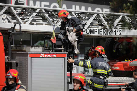 Bucharest, Romania - August 6, 2020: Firefighters try to extinguish a fire that spread across an...