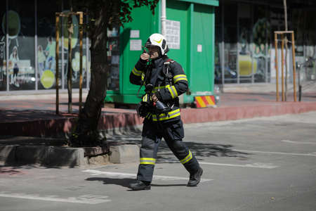 Bucharest, Romania - August 6, 2020: Firefighters try to extinguish a fire that spread across an...
