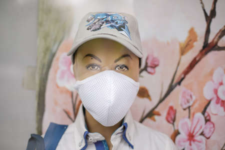 Bucharest, Romania - September 4, 2020: Details with a kid mannequin equipped for school with a protective mask in a shop window.のeditorial素材