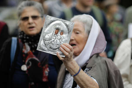 Bucharest, Romania - October 10, 2020: Details with a senior woman holding an Orthodox Church icon during a political rally.のeditorial素材