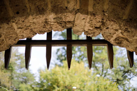 Wooden spikes gate of a sliding door (portcullis) at the entrance of a medieval fortressの写真素材