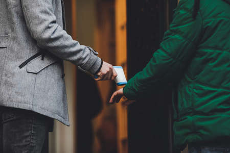 Details with the hands of a man taking the temperature and also disinfecting the hands of people...