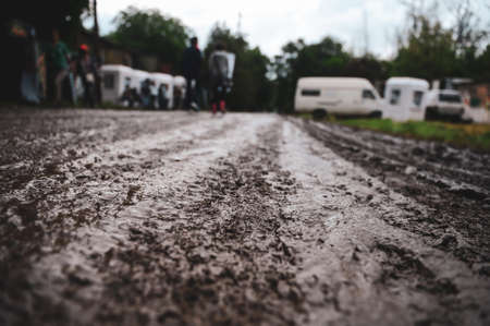 Shallow depth of field (selective focus) image with the mud on an unpaved road during a rainy summer day at a music festival.の写真素材