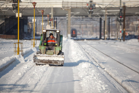 Bucharest, Romania - January 5, 2016: Man driving a small excavator to remove snow from the Northern...
