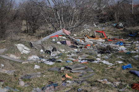 Shallow depth of field details of garbage and construction debris scattered all around an empty lot...