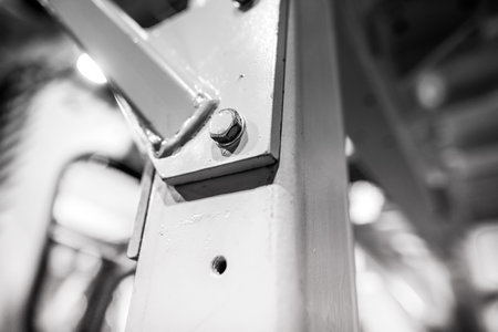Shallow depth of field (selective focus) image with details of industrial metallic nuts and bolts in a heavy factory.の写真素材