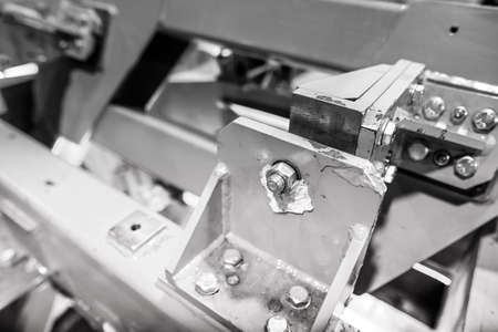 Shallow depth of field (selective focus) image with details of industrial metallic nuts and bolts in...