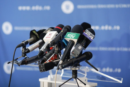 Bucharest, Romania - March 23, 2021: Shallow depth of field (selective focus) image with  microphones from various Romanian news televisions before a press conference.のeditorial素材