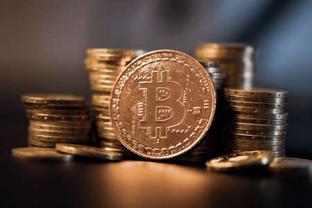 Shallow depth of field (selective focus) image with a Bitcoin metal coin near other metal coins - cryptocurrency concept.の写真素材