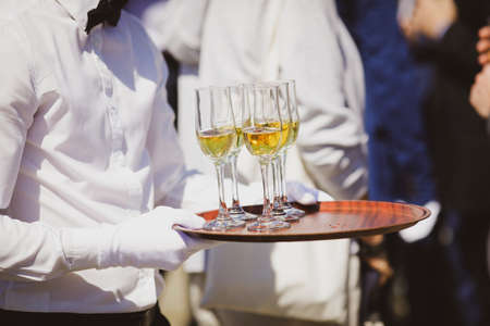 Shallow depth of field (selective focus) details with a waiter walking around and giving sparkling...