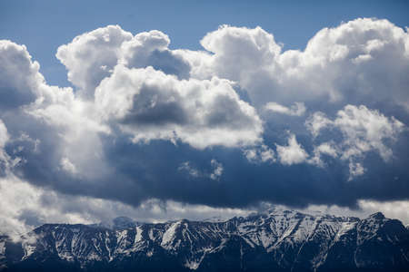 Heavy clouds over the Bucegi mountains in Romania during a spring day, as seen from the hills of Pestera village.の写真素材