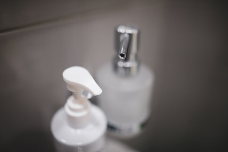 Shallow depth of field (selective focus) image with liquid soap dispensers in a bathroom.の写真素材