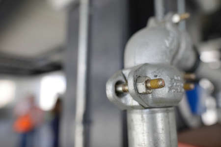 Shallow depth of field (selective focus) image with details of industrial metallic nuts and bolts in a heavy factory.の写真素材