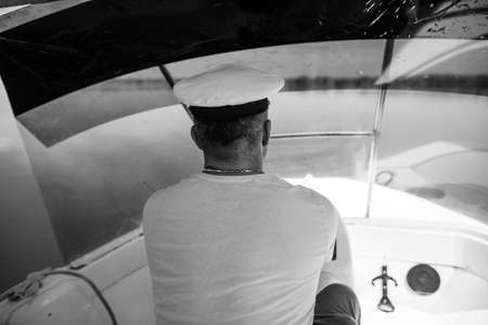 Shallow depth of field (selective focus) image with a small boat driver (captain,skipper).の写真素材
