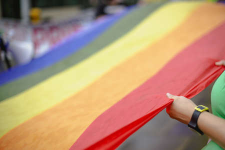 People hold a rainbow banner during a LGBTQ gay pride protest.