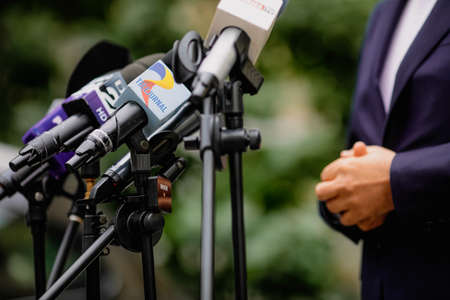 Bucharest, Romania - September 23, 2021: Shallow depth of field (selective focus) image with  microphones from various Romanian news televisions during a press conference.のeditorial素材