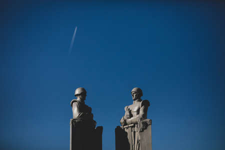 Bucharest, Romania - October 27, 2021: Communist/soviet style statue depicting soldiers with clear sky in the background at Monument to the Unknown Hero / Tomb of the Unknown Soldier.のeditorial素材