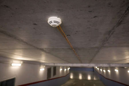 Shallow depth of field (selective focus) image with a smoke detector sensor  inside an underground parking.の写真素材
