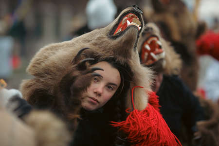 Bucharest, Romania - December 21, 2021: Young woman is wearing bear fur and performs a New Year Romanian traditional ritual (Bears Dance or Dansul Ursilor).のeditorial素材