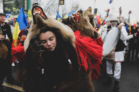 Bucharest, Romania - December 21, 2021: Young woman is wearing bear fur and performs a New Year Romanian traditional ritual (Bears Dance or Dansul Ursilor).のeditorial素材