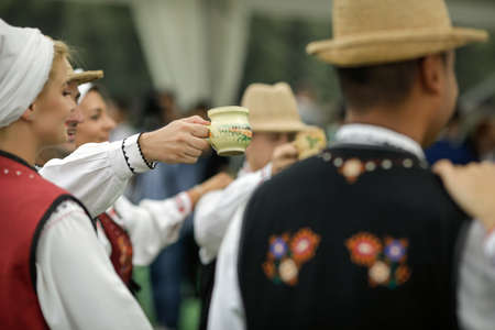 Braila, Romania - August 26, 2021: Men and women dressed in Romanian traditional costumes perform a...