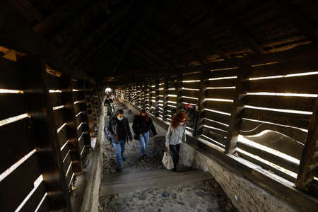 Sighisoara, Romania - 30 October 2021: People walk up and down the famous Covered Stairway (Scara acoperita) or The Scholars' Stairs, that lead up from the fortress and town centre up the hill.のeditorial素材
