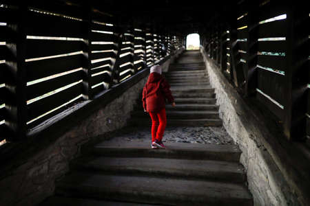 Sighisoara, Romania - 30 October 2021: Little girl walks up the famous Covered Stairway (Scara...