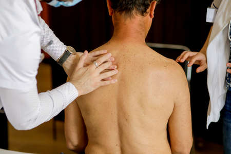 A medic and a female resident medic check the health of a male patient.の写真素材