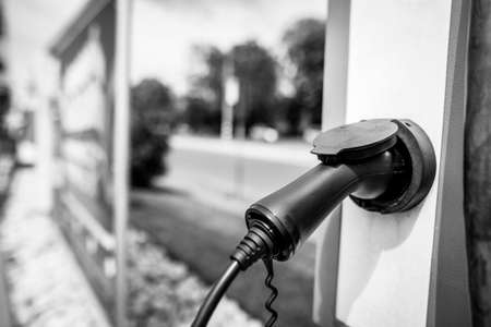 Shallow depth of field (selective focus) details with auto electric plug or socket at an electric vehicle charging station.の写真素材