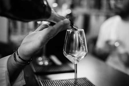Shallow depth of field (selective focus) details with sparkling wine being poured into a glass at a bar.の写真素材
